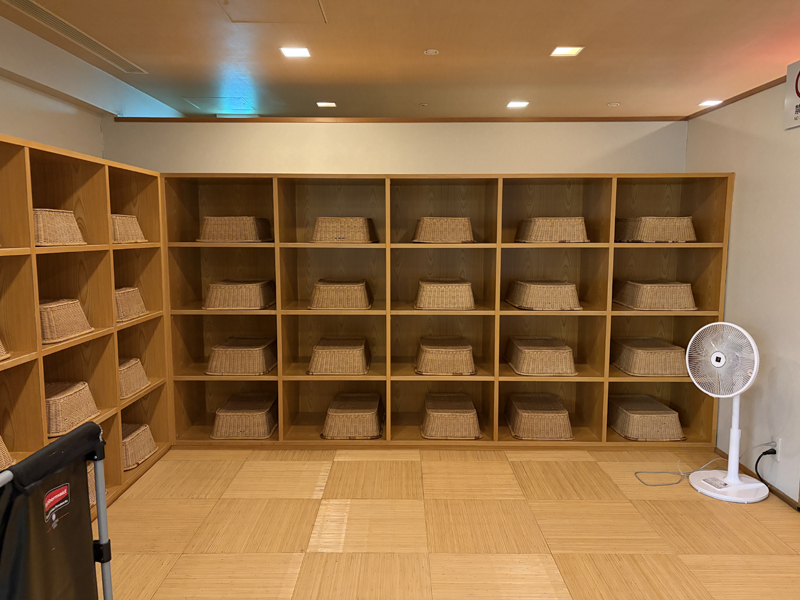 木製の棚に並べられた脱衣かご