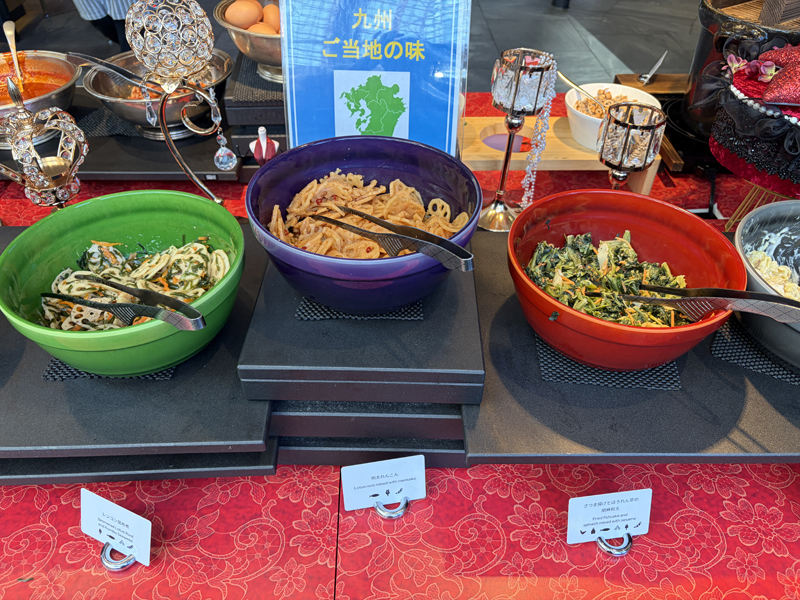 各種大皿に入って並んでいるレンコンの昆布煮、明太レンコン、さつま揚げとほうれん草の胡麻和え