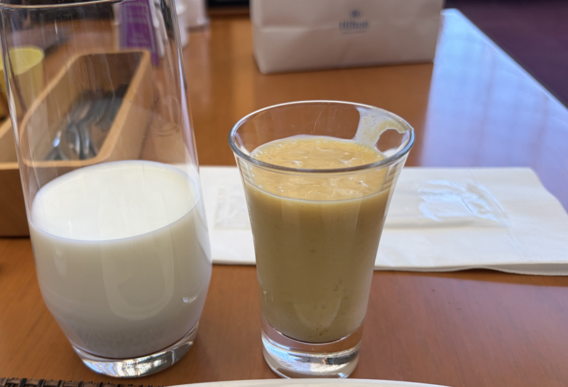 テーブルに置かれたマンゴースムージーと牛乳のグラス