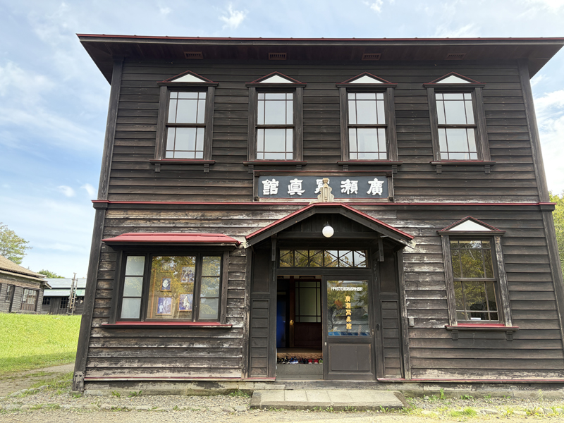 旧廣瀬写真館の外観。木造2階建ての洋風建築で、中央に右書きで「廣瀬寫眞館」の木製看板が掲げられている様子