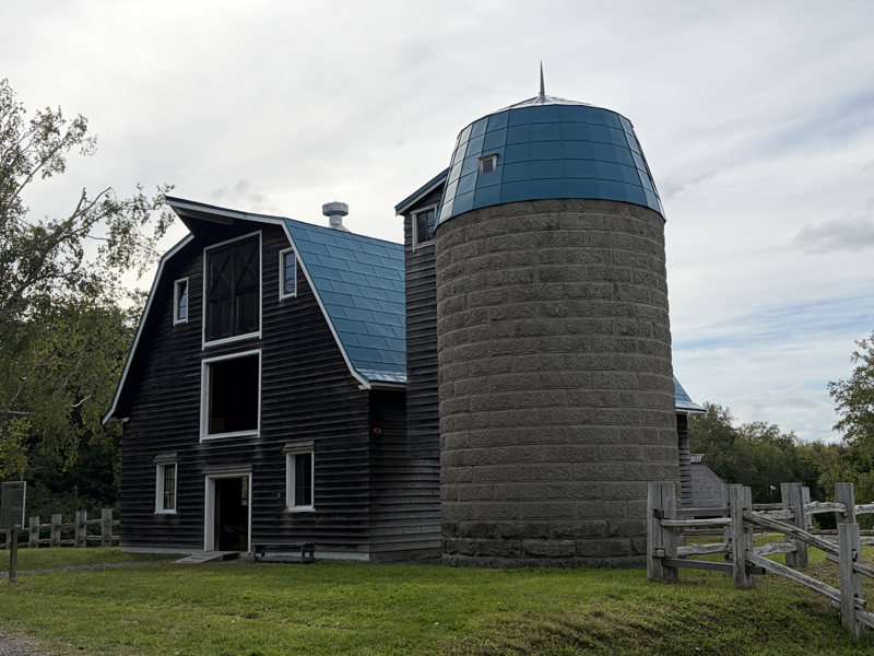 北海道開拓の村の旧小川家酪農小屋。石造りの大きなサイロと青い屋根の木造牛舎が立ち並ぶ風景