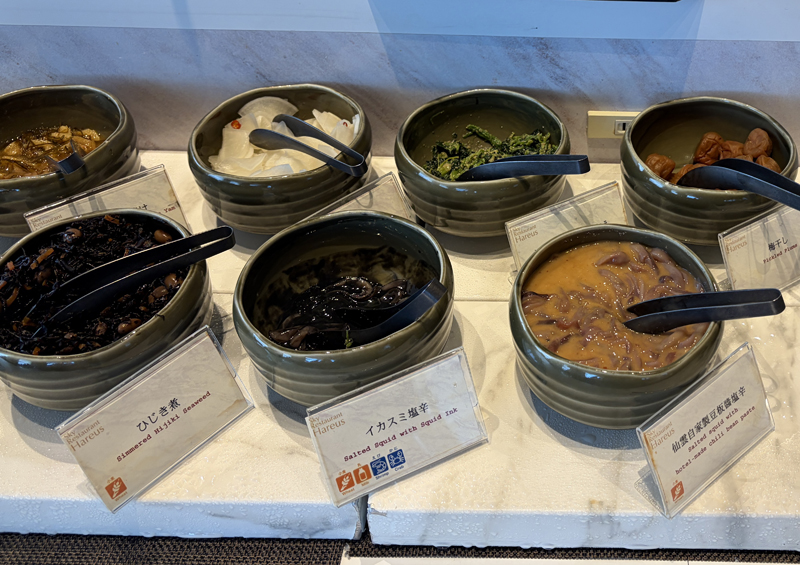 小鉢に入ったご飯のおとも(松前漬け、大根の漬物、ほうれん草の胡麻和え、梅干し、ひじき、イカスミ塩辛、イカの塩辛