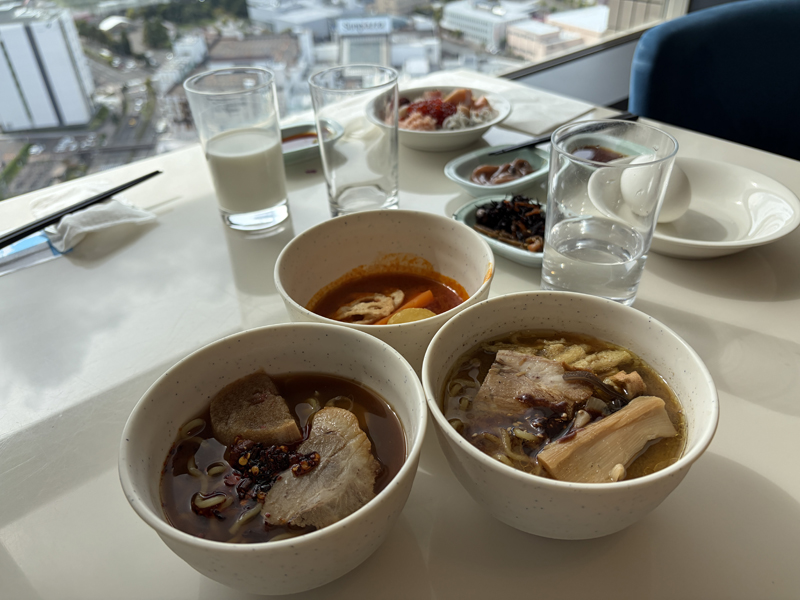 醤油ラーメン、味噌ラーメン、スープカレーが並んだ朝食テーブル